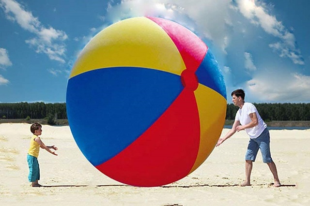 パパと子供が大きなビーチボールで遊ぶ様子