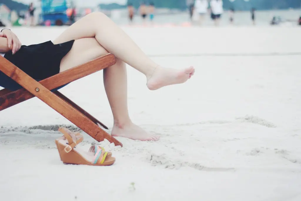 砂浜で椅子に座っている人の足