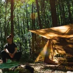 森林の中でソロキャンプする男性