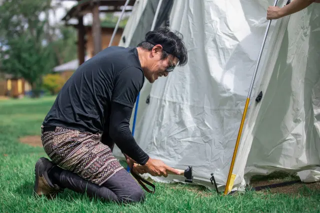 男性がペグを打っている様子