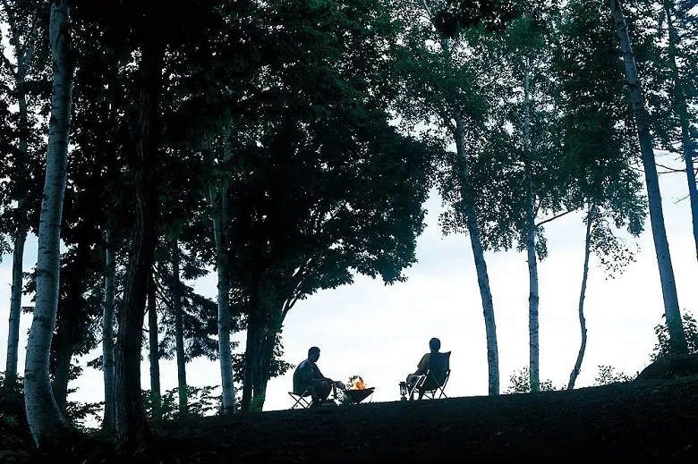 森の中で焚き火をする人